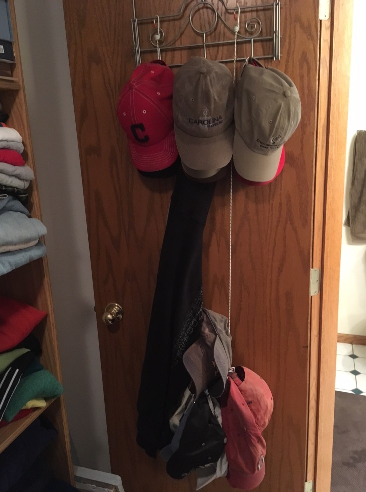 22 hats hanging in a dad's closet