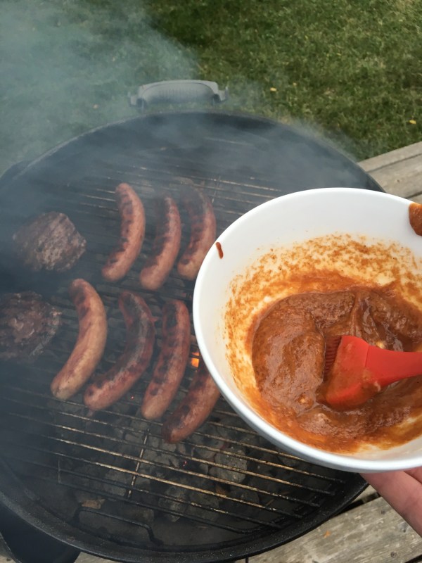 brats on the grill about to be basted