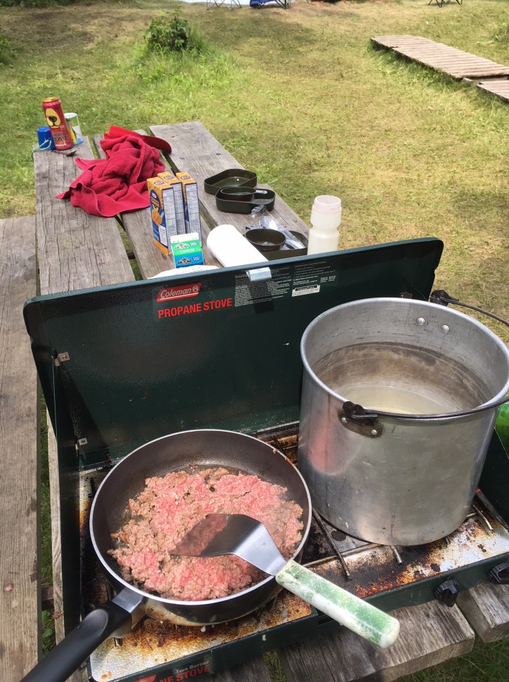 boiling water and browning hamburger on camp propane stove