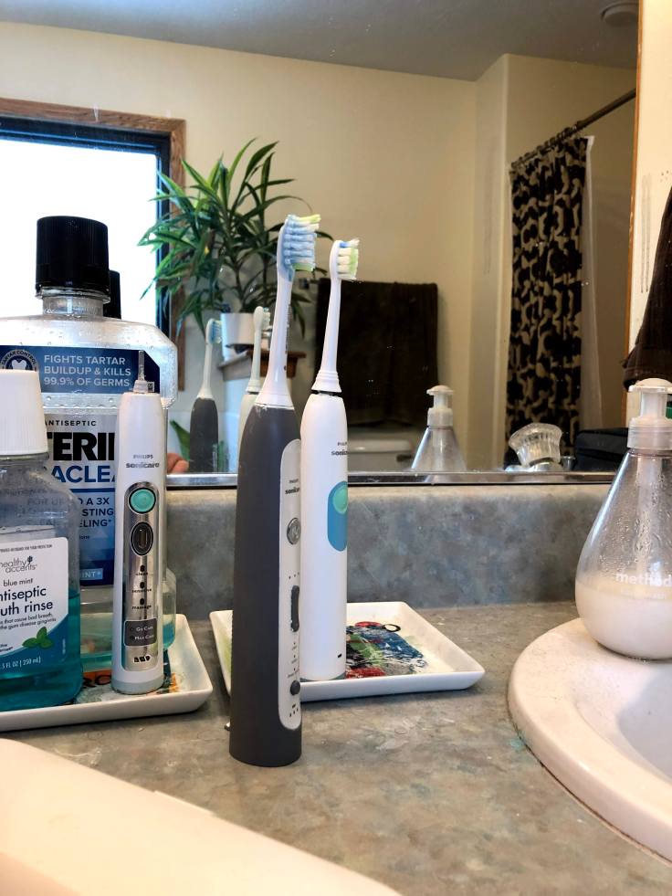 Three electric toothbrushes stand sentry over my side of the sink. Why? Because: Dad.